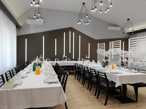 a dining room with white tables and black chairs at Jurajska Przystań in Jastrząb