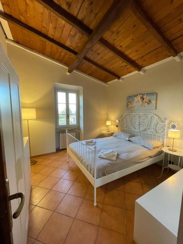 1 dormitorio con cama blanca y techo de madera en Il Casale di B, en Acilia