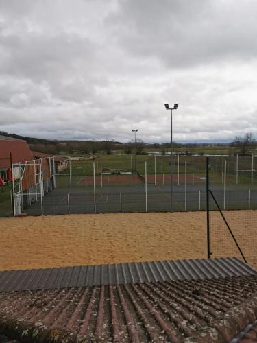 an empty tennis court with a tennis court at Activités Et Nature Appartement in Vignot