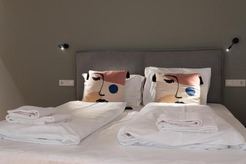 a bed with two pillows with faces on it at Mint@Naschmarkt Premium Apartments in Vienna