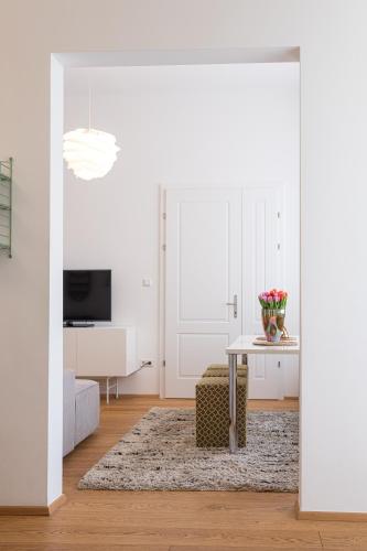 a white living room with a table and a couch at Mint@Naschmarkt Premium Apartments in Vienna