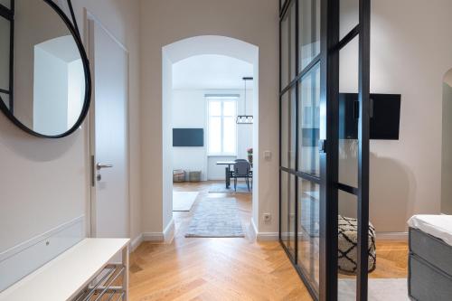 a living room with a mirror and a hallway at Mint@Naschmarkt Premium Apartments in Vienna