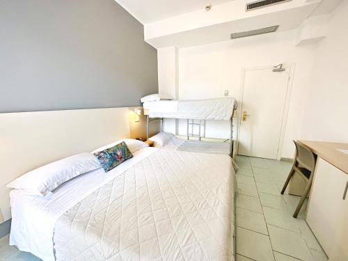 a small room with a bed and a desk at Aura Living Hotel in Rimini