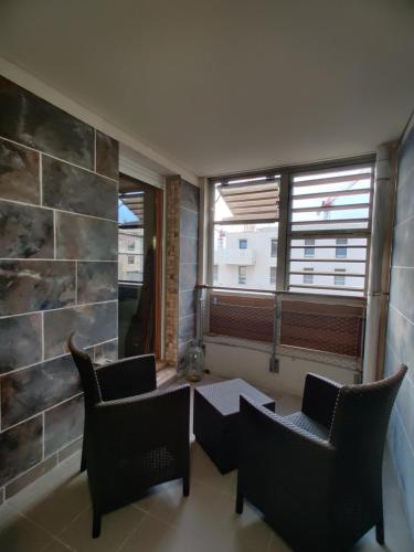 une chambre avec deux chaises, une table et une fenêtre dans l'établissement Le Village 76 m2 Climatisation 1er arrondissement gare à pied, à Marseille
