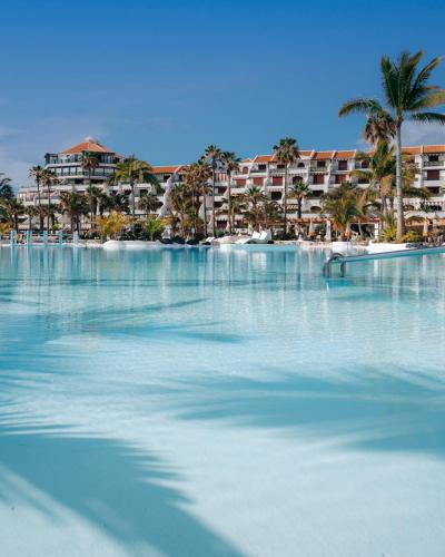 a large body of water with palm trees and buildings at Parque Santiago IV Official in Playa de las Americas