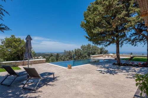 um pátio com 2 cadeiras e uma piscina em Sunshine Villa em Rethymno Town