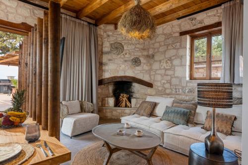 a living room with a couch and a fireplace at Sunshine - Fairytale Countryside Villa by etouri in Rethymno