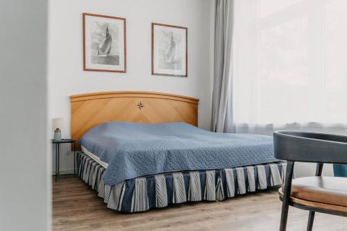una camera con un letto e una coperta blu di Blue Seagull Taikos 13-28 a Nida