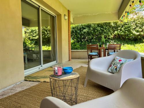 une terrasse couverte avec une chaise blanche et une table dans l'établissement T3 Centre ville avec Terrasse + Parking, à Toulouse
