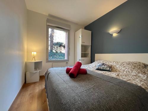 Un dormitorio con una cama con un objeto rojo. en T3 Centre ville avec Terrasse + Parking, en Toulouse