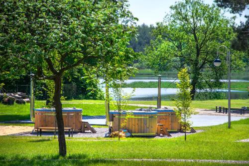 a park with three barrels and a tree in the grass at Jurajska Przystań in Jastrząb