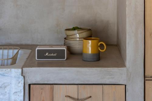 a kitchen counter with a coffee cup and a scale at Homa Serifos pool villas in Serifos Chora