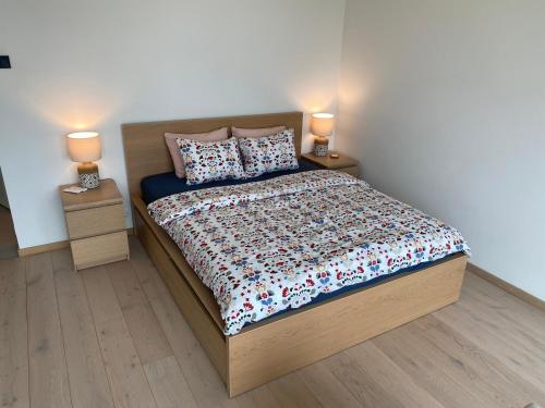 a bedroom with a bed with two night stands and two lamps at Modern Lux Apartment with Great View in Tallinn