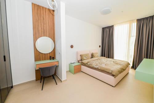 a bedroom with a bed and a desk and a mirror at Green Cost Luxury Apt 239 in Palasë