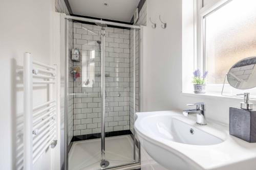 baño blanco con ducha y lavamanos en COSY HOME NEAR DORNEY, WINDSOR & Free Parking en Taplow