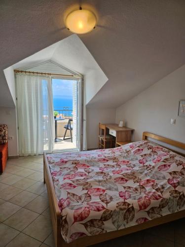 a bedroom with a bed with a view of the ocean at Apartments Adriatika in Makarska