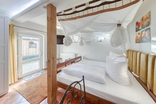 1 dormitorio con cama con dosel y ventana en Kutscherhaus, en Linstow