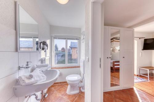 a white bathroom with a sink and a toilet at Kutscherhaus in Linstow