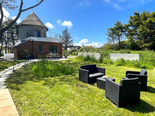 une cour avec deux canapés devant un bâtiment dans l'établissement MOULIN DE KERNOT, à Cléden-Cap-Sizun