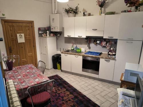 a kitchen with white cabinets and a table and a stove at Sweet Night in Perugia
