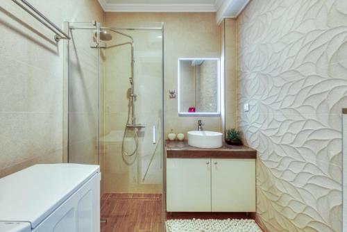 bagno con doccia, lavandino e specchio di Deluxe Cosmopolit apartment a Cavtat