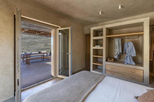 a bedroom with a bed and a sliding glass door at Homa Serifos pool villas in Serifos Chora