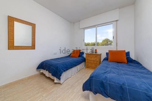 een slaapkamer met twee bedden en een spiegel bij Aguamarina Playa in Orihuela