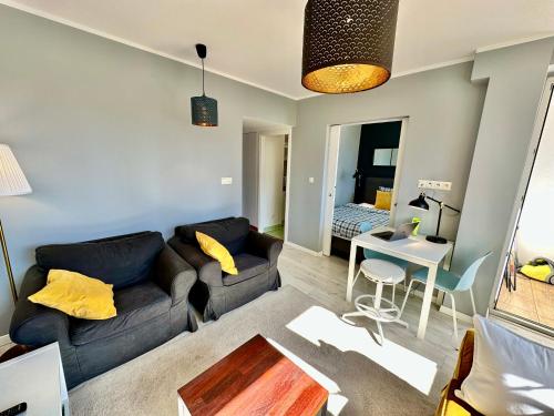 a living room with a couch and a table at GOLD 2 King Size Bed, metro x2 free WiFi, 50'TV Netflix, HBO, AppleTV+ in Warsaw