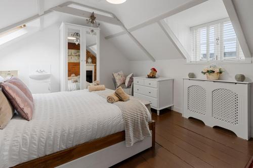 ein weißes Schlafzimmer mit einem weißen Bett und einer weißen Kommode in der Unterkunft Pip's Cottage by Staytor Accommodation in Exeter