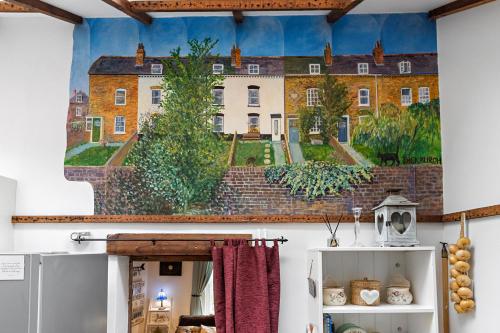 een schilderij van een huis aan de muur van een keuken bij Pip's Cottage by Staytor Accommodation in Exeter