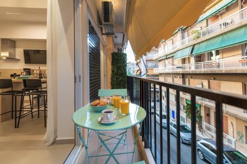 einen Balkon mit Tisch und Frühstück darauf in der Unterkunft Feel like home in Athen