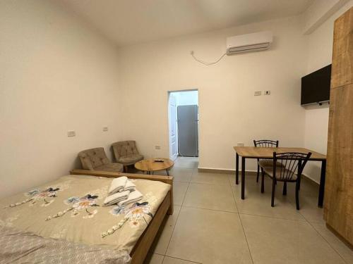 1 dormitorio con cama, mesa y comedor en Apartment with terrace sea view, en Haifa