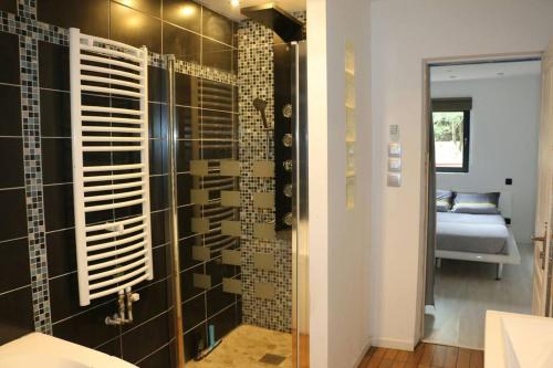 ein Bad mit einer Dusche und einer Glaswand in der Unterkunft Détente assurée dans ce logement avec balnéo in Rezé