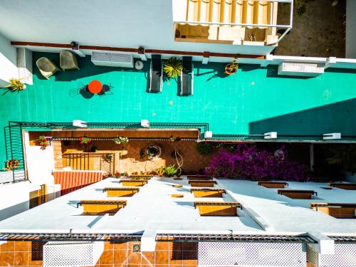 Marbella Village في مربلة: طاولة طويلة مع كراسي صفراء وجدار أخضر