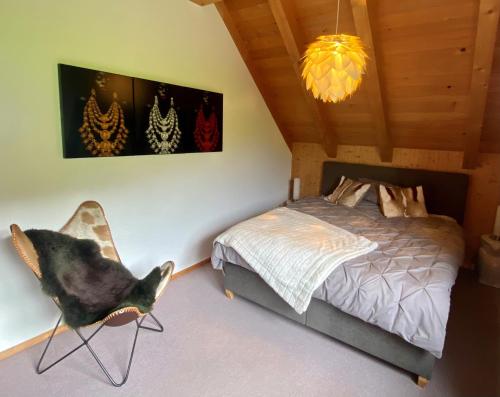 a bedroom with a bed and a chair at Doppelzimmer in charmantem B&B in Hemberg