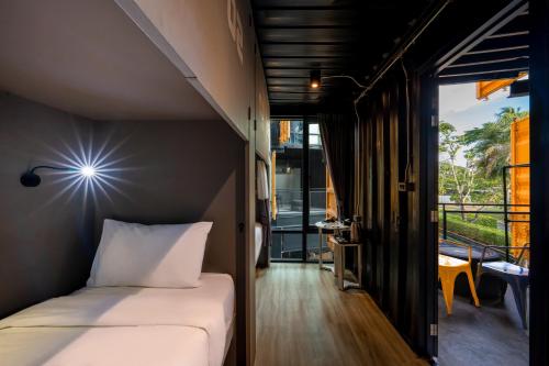 a small bedroom with a bed and a balcony at Hivetel in Chalong 
