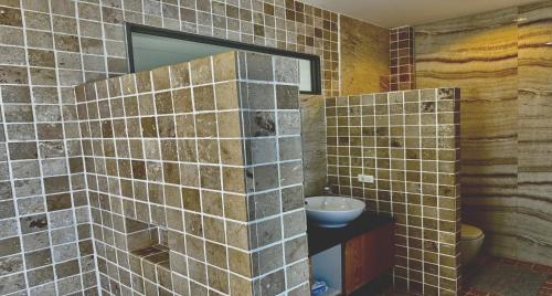 a tiled bathroom with a sink and a mirror at Villa Jacuzzi Seaview Villa in Chaweng Noi Beach