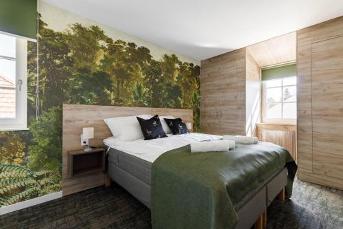 a bedroom with a large bed with a painting on the wall at PARK Apartmanok in Balatonszárszó