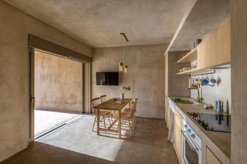 a kitchen and dining room with a table and chairs at Homa Serifos pool villas in Serifos Chora