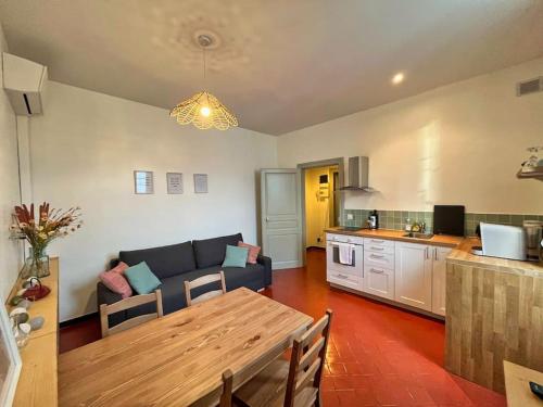 Il dispose d'une cuisine et d'un salon avec un canapé et une table. dans l'établissement Clemence - Charmant T2 Calme et Lumineux, à Châteaurenard