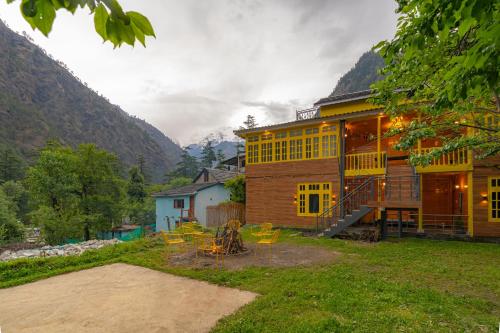 a house with chairs and tables in front of it at Whoopers Boutique Kasol in Kasol