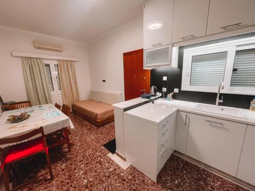 a kitchen with white cabinets and a table in a room at Hector Villa Airport by Airstay in Artemida