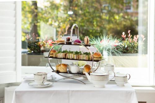 a tray of pastries and tea cups on a table at The Roseate Villa Bath in Bath