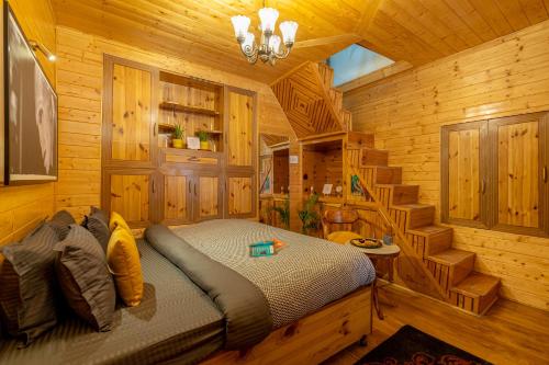 ein Schlafzimmer mit einem Bett in einer Holzhütte in der Unterkunft Whoopers Boutique Kasol in Kasol