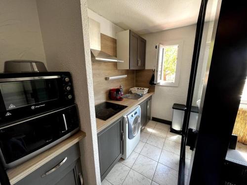 Il comprend une petite cuisine équipée d'un évier et d'un lave-vaisselle. dans l'établissement Joli appartement T2 centre port avec wifi, au Cap d'Agde