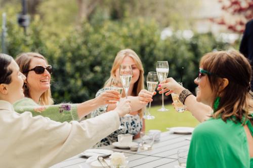 a group of people holding champagne glasses at a table at The Roseate Villa Bath in Bath