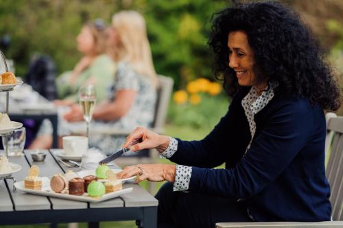 a woman sitting at a table with a plate of food at The Roseate Villa Bath in Bath