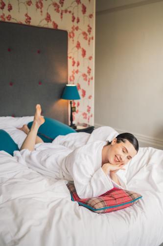 a woman laying in bed with her head on a pillow at The Roseate Villa Bath in Bath