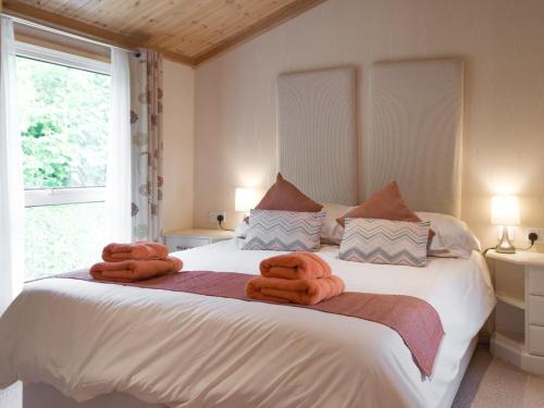 a bedroom with a large bed with towels on it at Badger Lodge in Burton