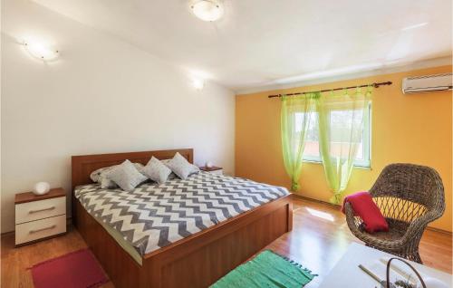 a bedroom with a bed and a chair and a window at Beautiful Home In Pula With Wifi in Pula